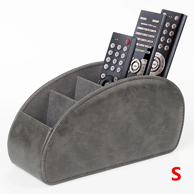 A gray PU leather caddy organizer holding three black TV remotes.