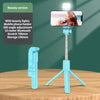 A light blue selfie stick tripod with an LED fill light and Bluetooth remote is displayed on a wooden table.
