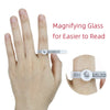 A hand demonstrates a magnifying glass ring sizer and measuring tool for easier reading.