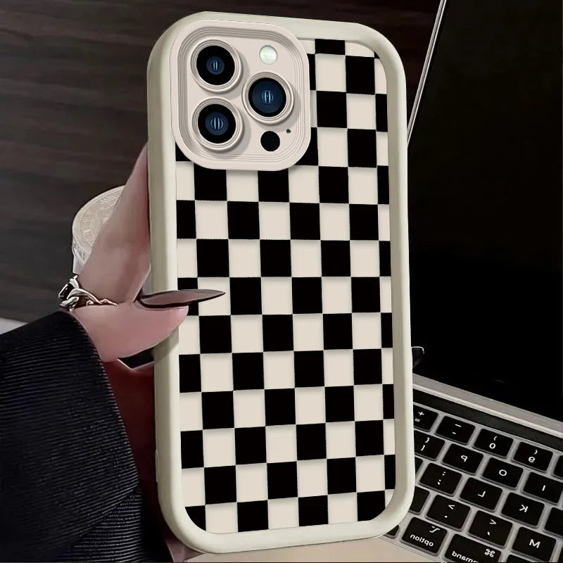 A white checkered silicone phone case is shown on a smartphone next to a laptop.