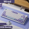 Eine weiße mechanische Tastatur mit lila Tastenkappen und RGB-Hintergrundbeleuchtung auf einem Schreibtisch.