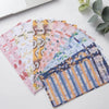 A stack of colorful A6 budget planner binders with envelope pockets and expense sheets