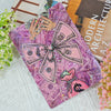 Lila gemusterte Karte mit Cartoon-Illustration von Geld und pinker Handtasche.