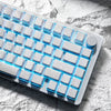 Nahaufnahme einer weißen mechanischen Tastatur mit Kohlenstoffmuster-Tastenkappen und blauem LED-Licht.