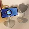 A silver adjustable desktop stand holding a smartphone displaying a map view of the Earth.