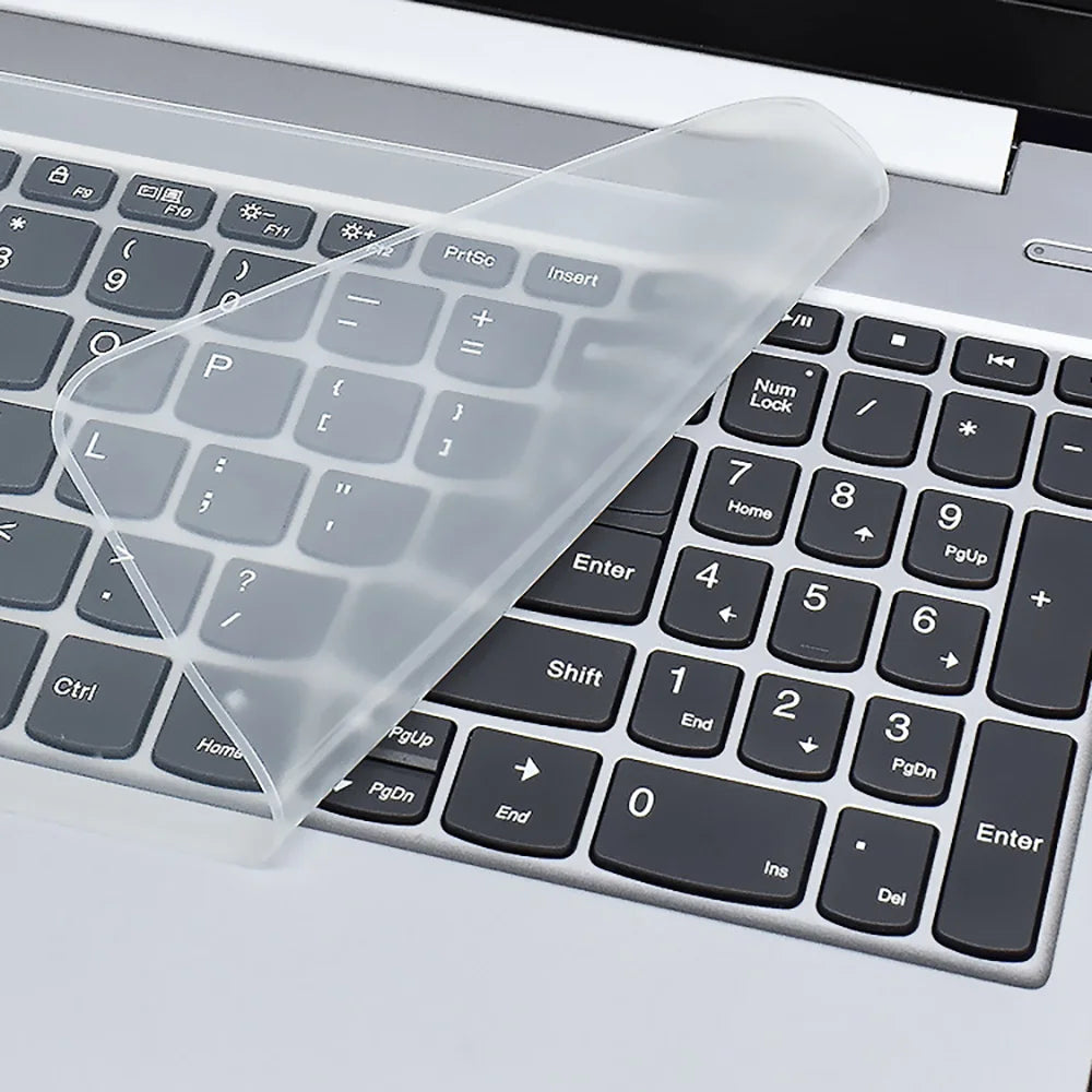A clear silicone keyboard cover is placed over a laptop keyboard, showing the keys underneath.