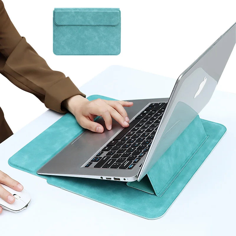 Ein Laptop liegt auf einer türkisen Kunstlederhülle neben einer passenden Hülle, während eine Hand auf dem Laptop tippt.