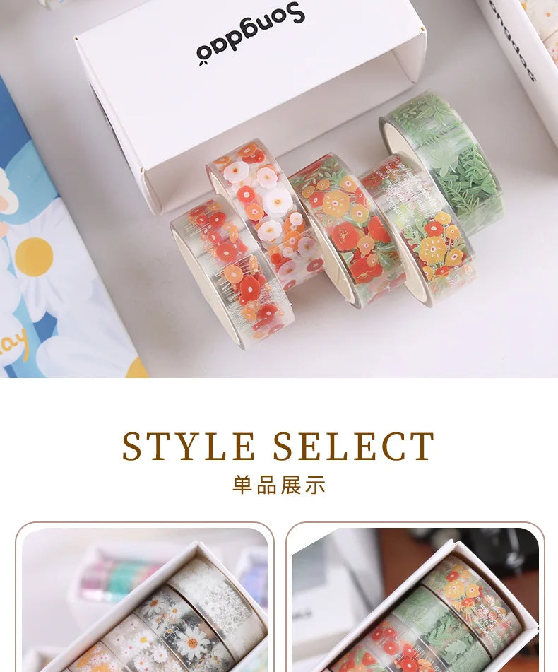 A set of decorative transparent washi tape rolls in various floral and greenery patterns displayed next to a box.