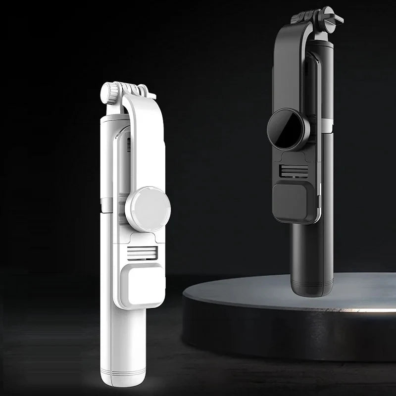 A white Bluetooth selfie stick with an LED fill light and tripod stand shown against a dark background.