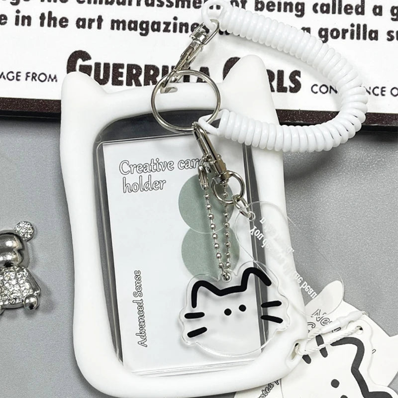 A white crystal clear card holder with a cat silhouette charm attached to a white cord keychain.