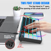 Gros plan d'un clavier de jeu mécanique compact avec un support de deux pieds et une main qui tape dessus.
