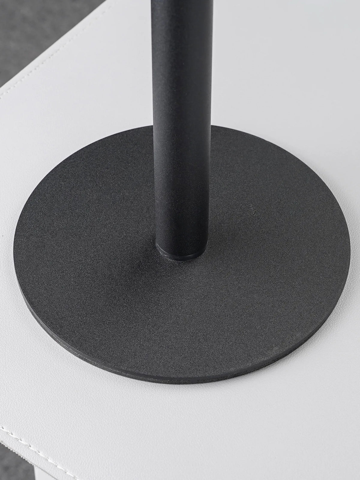 A black magnetic stand with a circular base and a vertical pole, designed to hold a phone or tablet.
