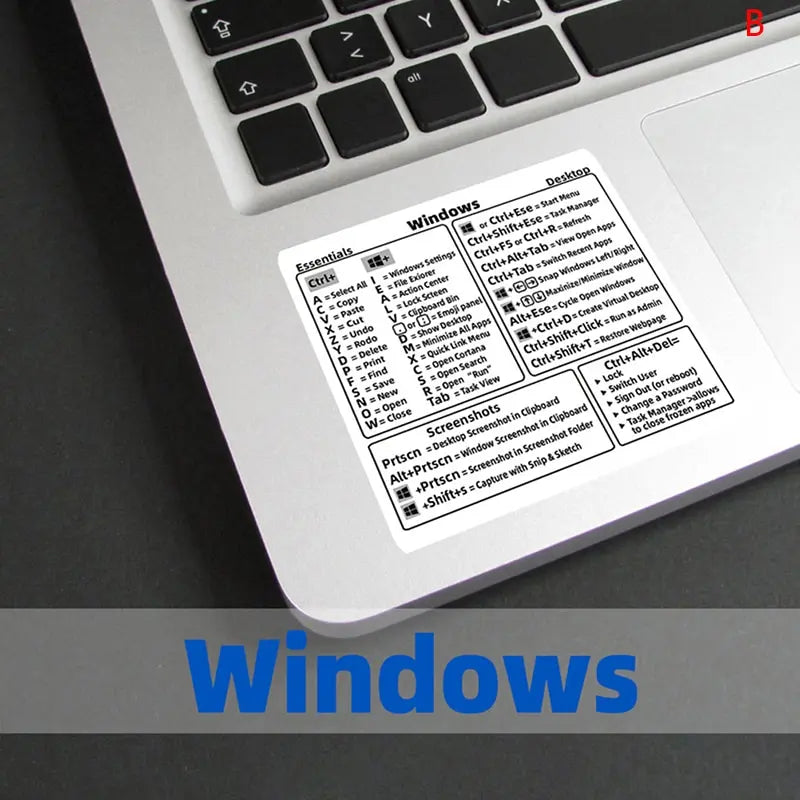 A close-up view of a Windows shortcut quick reference sticker on a laptop keyboard.