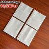A stack of ten A5 inner page photo card binder sleeves on a wooden surface.