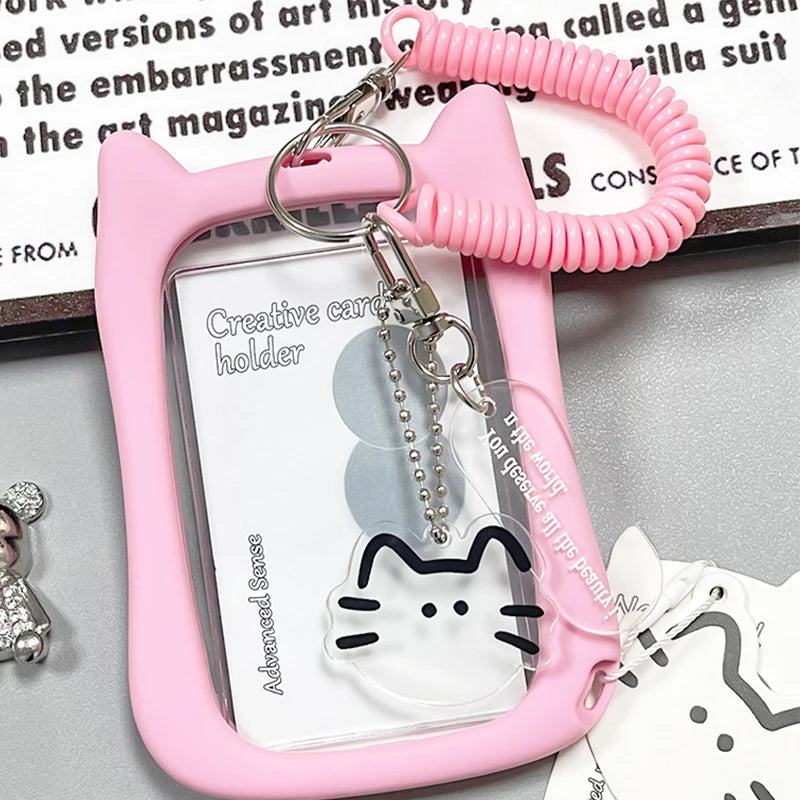A pink crystal clear card holder with a cat charm and a pink beaded keychain.