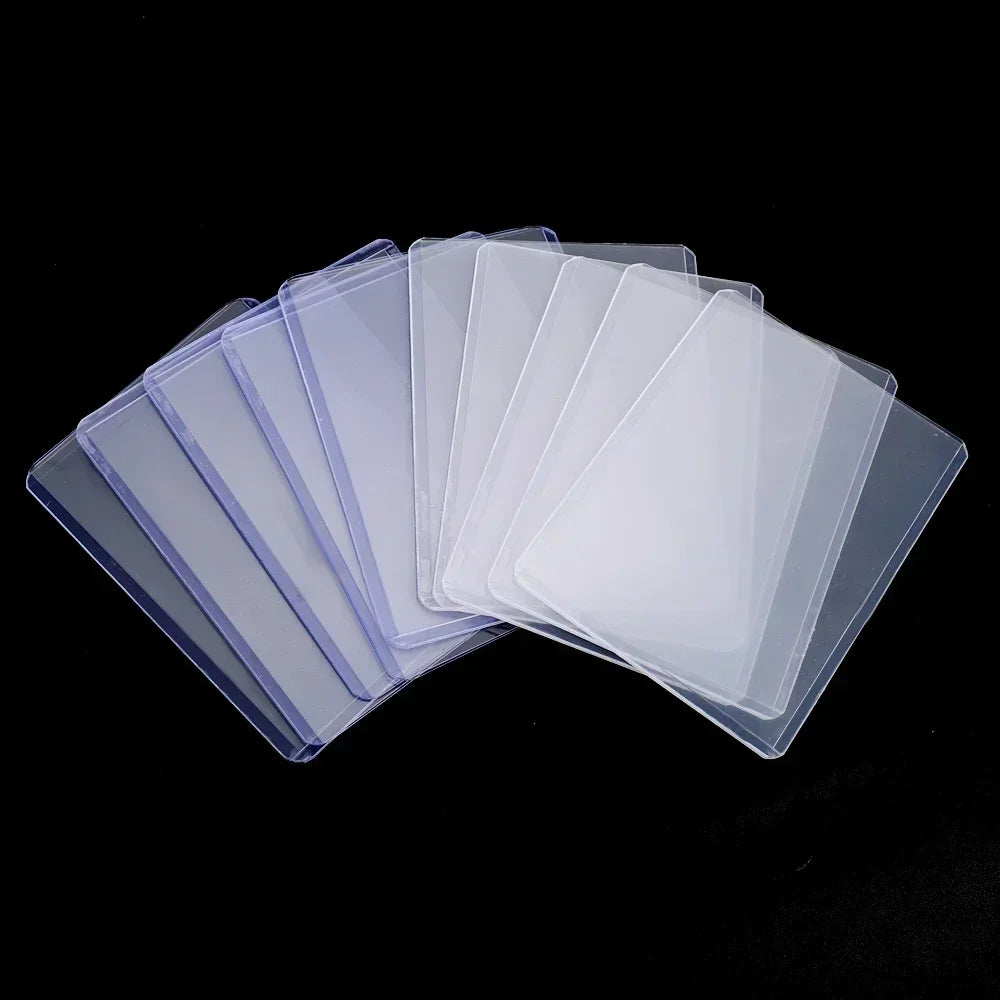 A stack of clear protective card sleeves with anti-scratch film arranged diagonally against a black background.