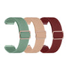Three colored elastic sports bands for Garmin watches in green, beige, and maroon.