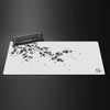 A white gaming mouse pad featuring a delicate black cherry blossom branch design.