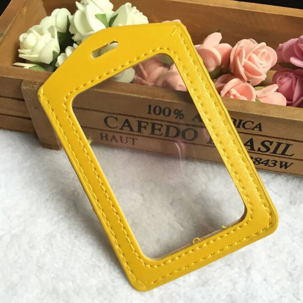 Yellow PU leather ID card holder with a cutout for a lanyard, resting on a wooden box.