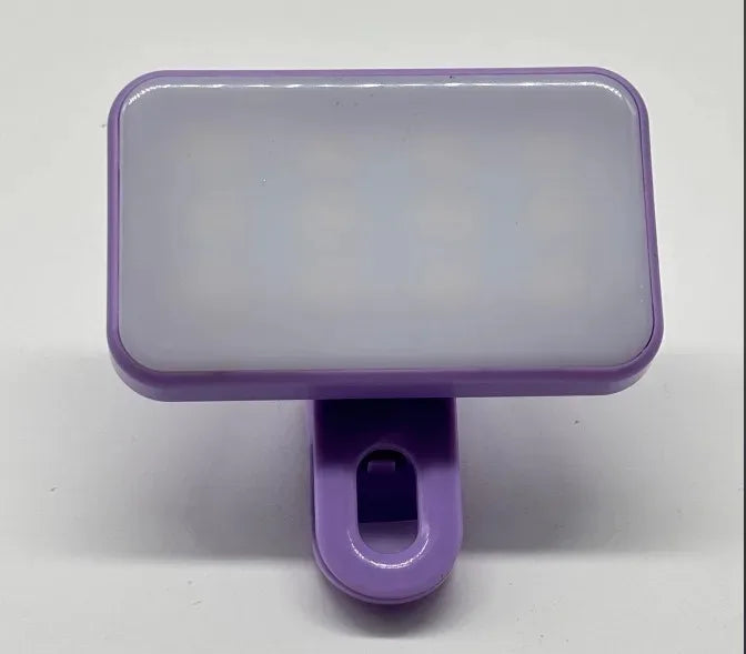 A purple portable rechargeable mini selfie light with a rectangular translucent body and a small clip.