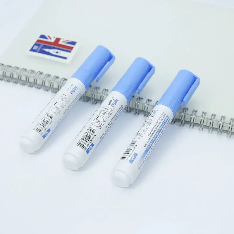 A pair of blue thermal paper erasers are displayed on a white surface next to a Union Jack flag.