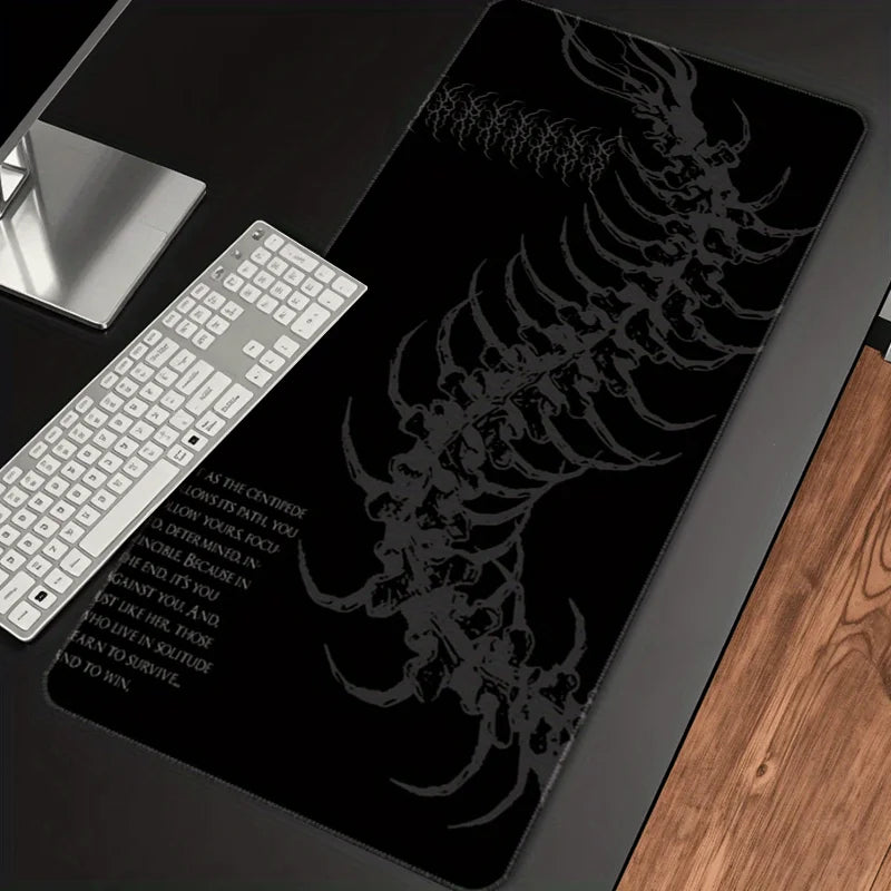 A black gaming mouse pad featuring a detailed silver gothic centipede design and an attached white keyboard.