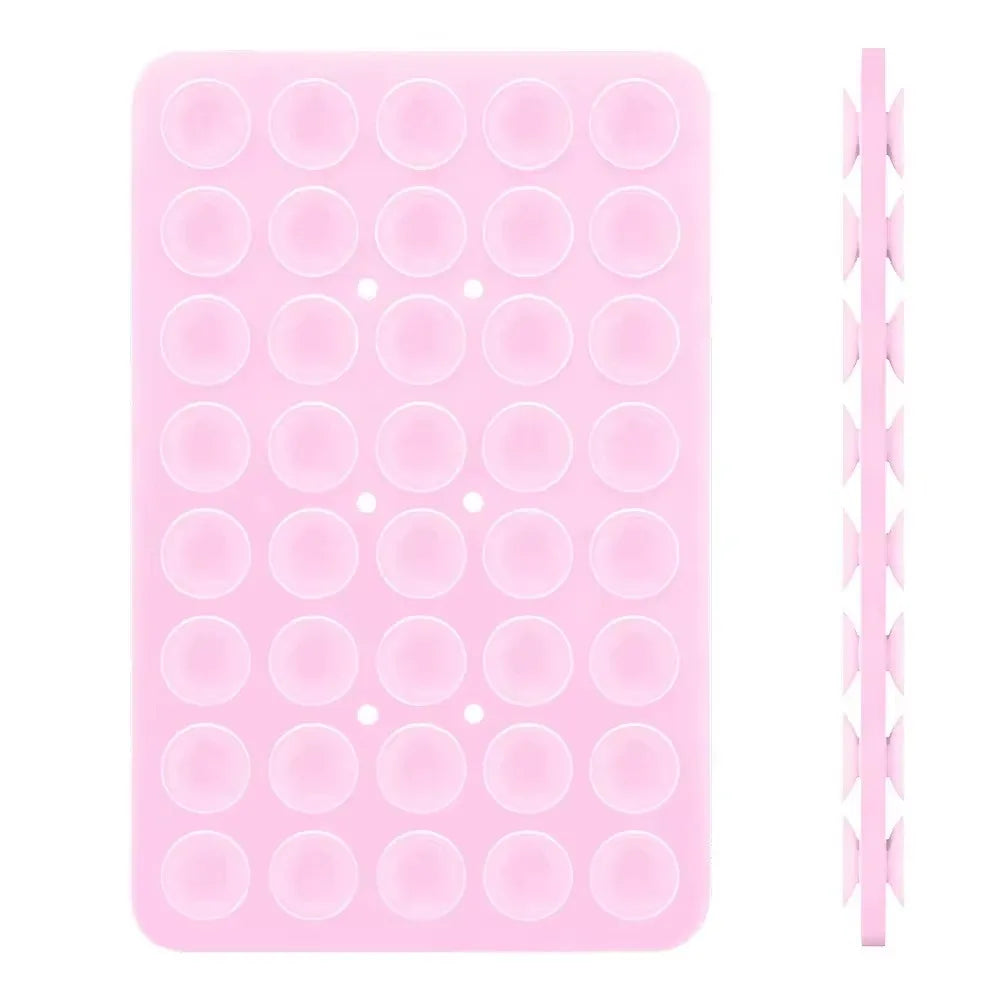 A pink double-sided silicone phone mount grip with multiple circular holes.