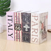 A set of three pink and gray mini dictionaries or safe for keys and valuables standing side by side.