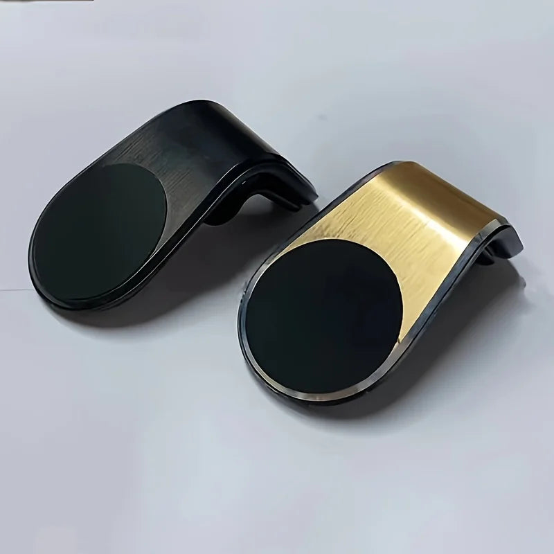 A magnetic car air vent phone mount in black and gold finishes.