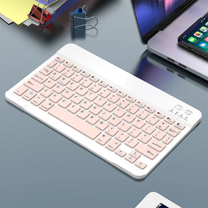 A white 10-inch Bluetooth keyboard and mouse combo with a pink keycap is shown on a gray desk.