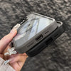 A hand holds a gray magnetic shockproof phone case for an iPhone against a dark background.