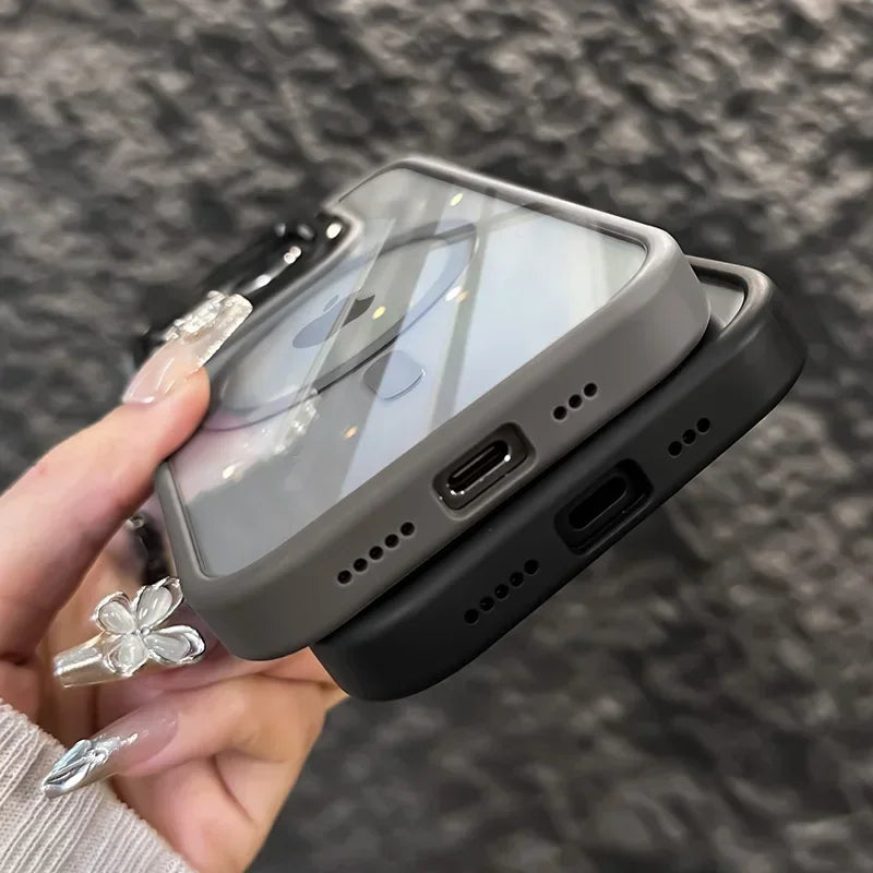 A hand holds a gray magnetic shockproof phone case for an iPhone against a dark background.
