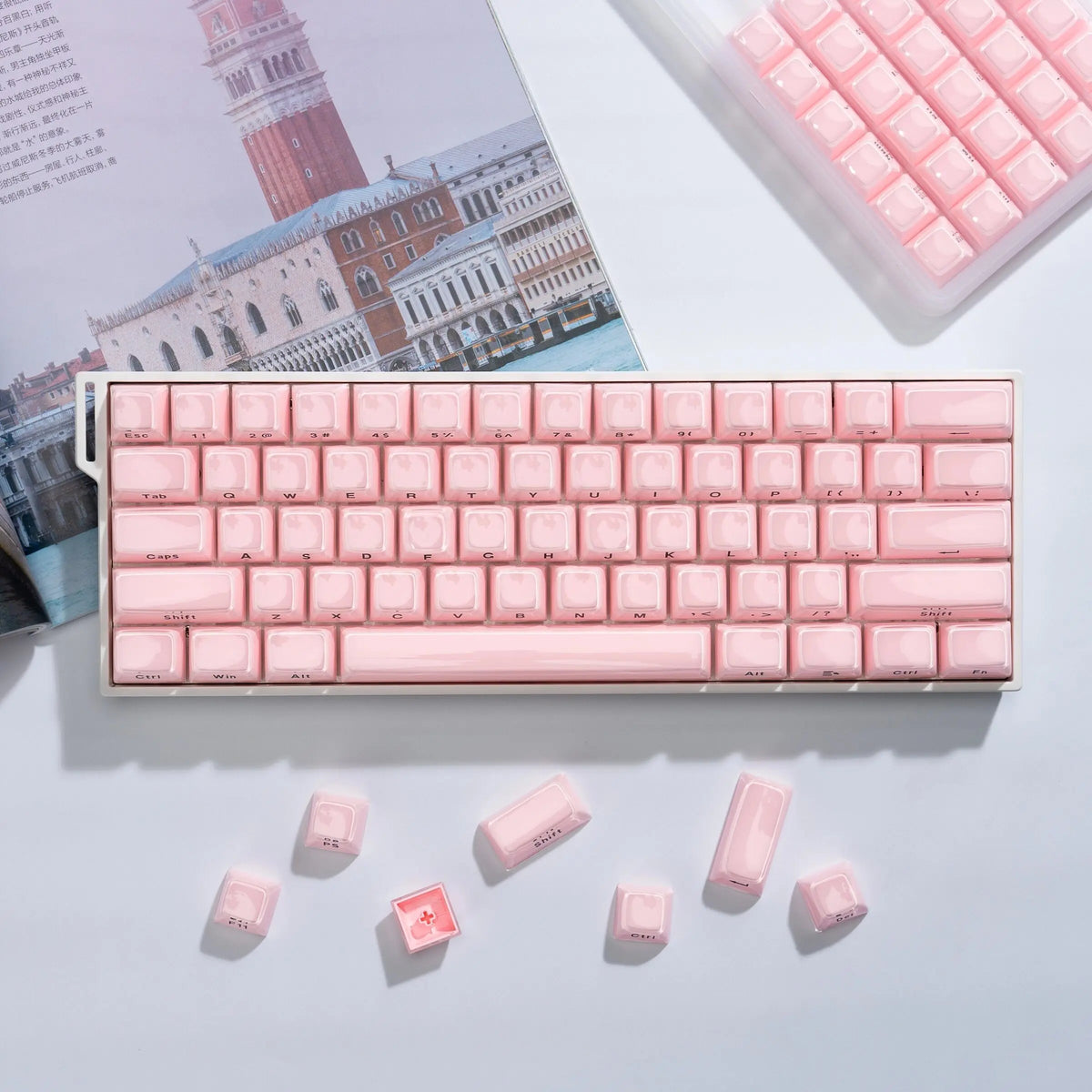 A close-up of a pink mechanical keyboard featuring translucent ice crystal keycaps and a matching pink keycap set.