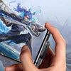 Une main tient un smartphone avec une nouvelle conception à chargement latéral, démontrant des commandes de jeu pratiques.