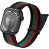 A black smartwatch with a green, red, and black striped hook and loop strap is shown on a wrist.
