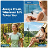 A woman uses a handheld fan outdoors, while another woman enjoys a desk fan near the sea.