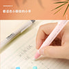 A hand is using a pink retractable pencil eraser on lined paper, with other pens and erasers visible.