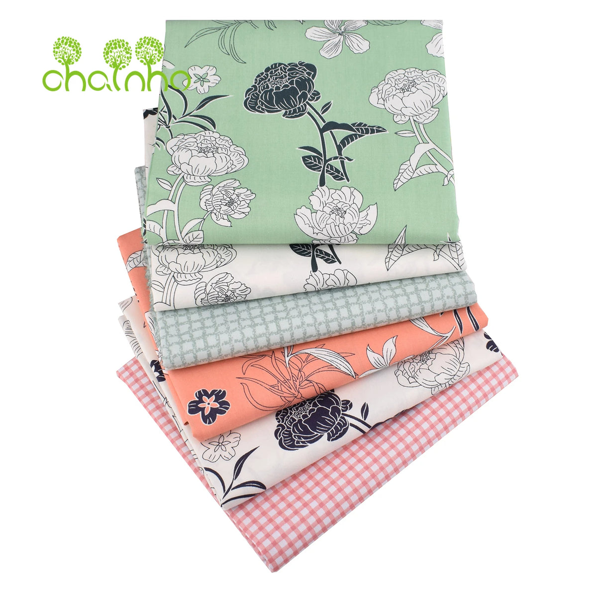 Gestapelte Twill-Baumwollstoffe mit Blumenmustern in Grün-, Weiß- und Rosatönen.