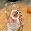 A hand holds a clear magnetic phone case with built-in magsafe compatibility on a wooden table.