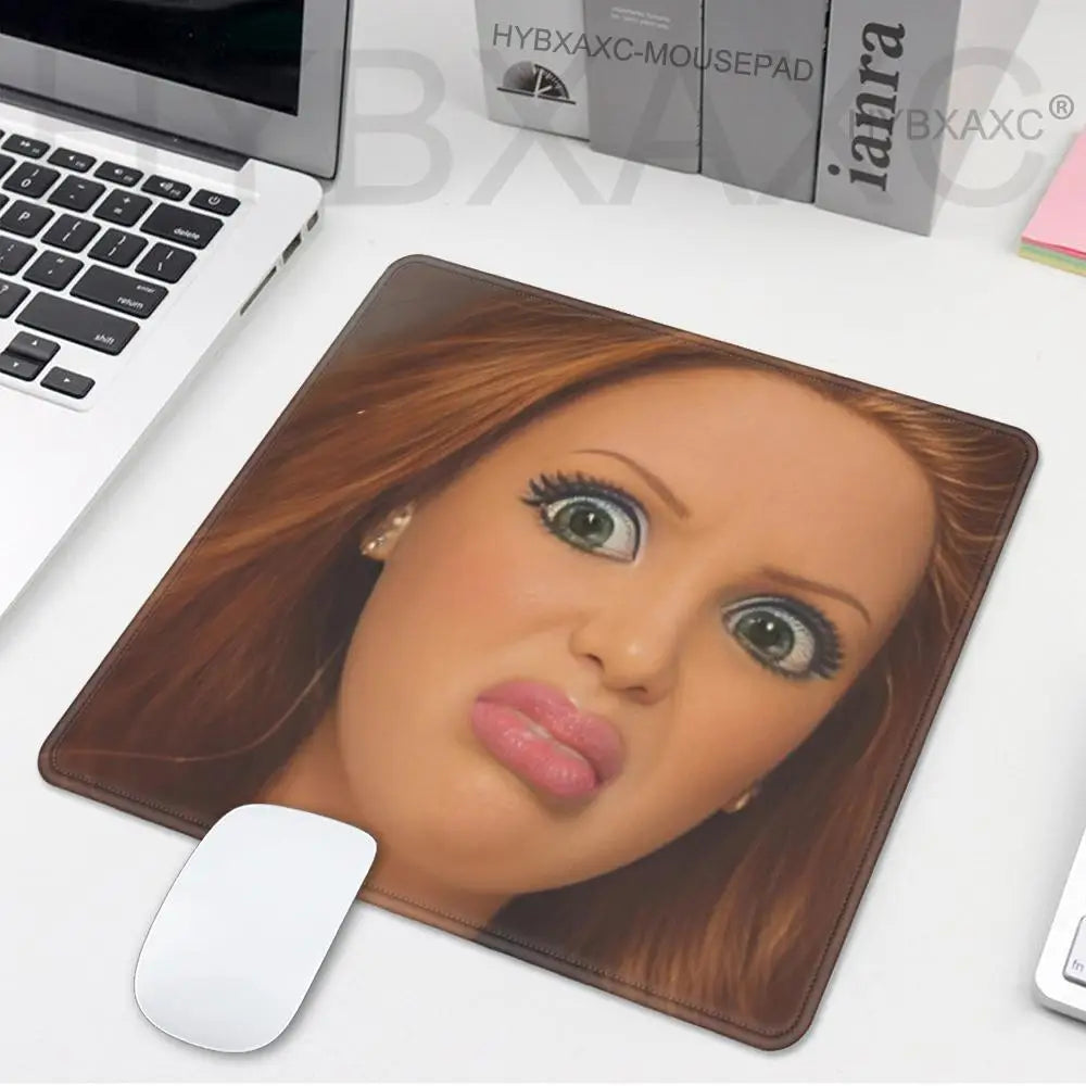 A brown desk mouse pad featuring a realistic female doll face with long brown hair and large eyes.