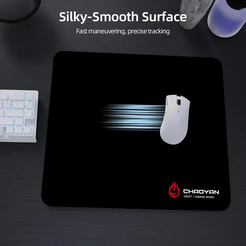 A black gaming mouse pad with a white mouse resting on it, featuring a silky-smooth surface.
