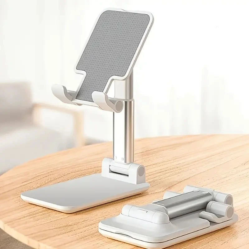 A silver desk mount clamp holding a tablet and a phone, with the mounting base visible on a wooden surface.
