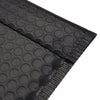A close-up view of black bubble mailers with a textured surface and a sealed edge.
