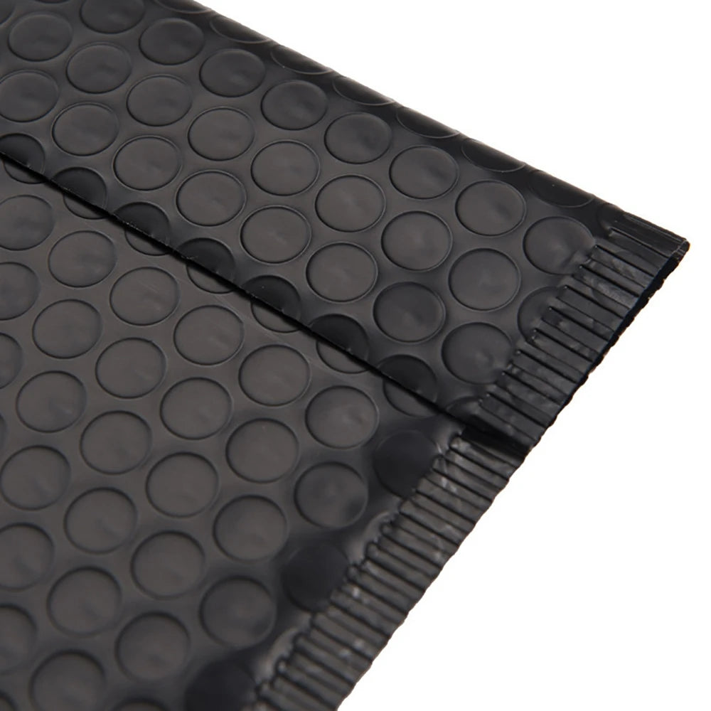 A close-up view of black bubble mailers with a textured surface and a sealed edge.