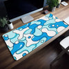 A blue and white abstract wave pattern mouse pad placed on a wooden desk next to a computer monitor.