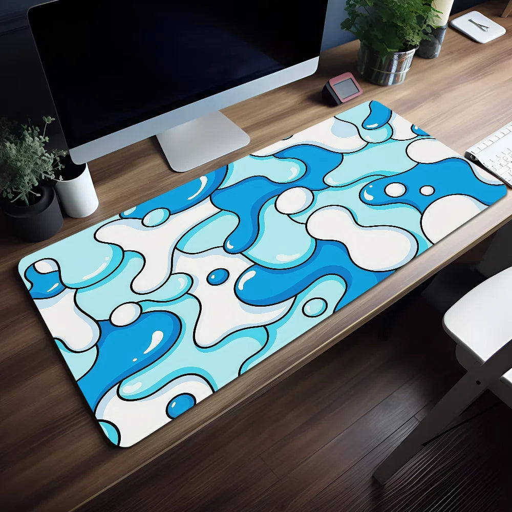 A blue and white abstract wave pattern mouse pad placed on a wooden desk next to a computer monitor.