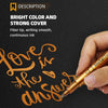 A hand is writing the phrase Love is the answer in orange metallic ink on a dark surface with a brush marker pen.