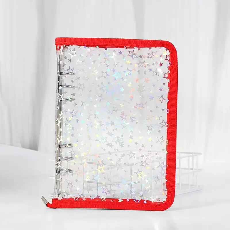 A red binder organizer with clear storage pockets filled with holographic star stickers.