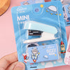 A hand holds a blue plastic package containing a mini stapler and a small card for students and office use.