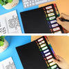A close-up of a black A4 file folder with monthly dividers and color tabs for organizing notes.